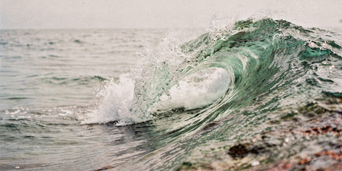 Sea-green wave breaking into foam